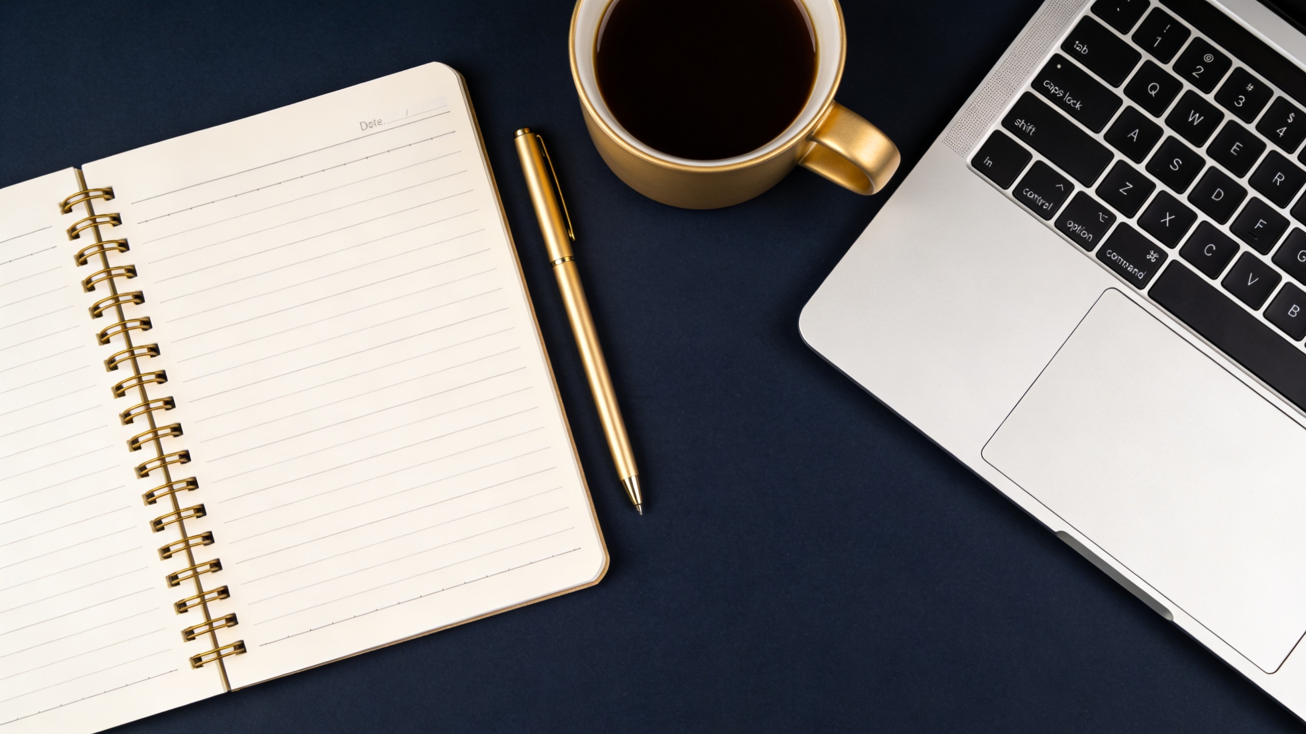 Minimalist flat lay of laptop, notebook and coffee on a dark desk, online business workspace